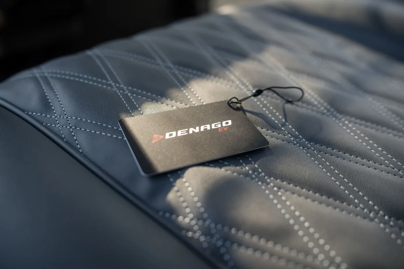 Denago tag on a diamond-stitched seat