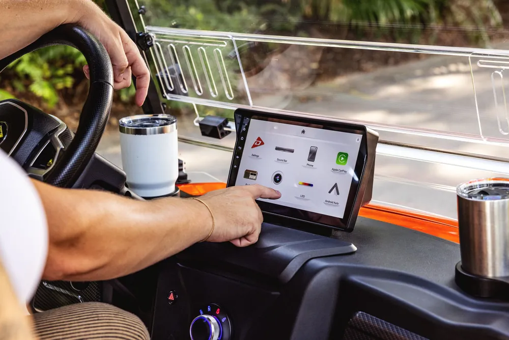 Driver using the touchscreen on a Denago Rover XL