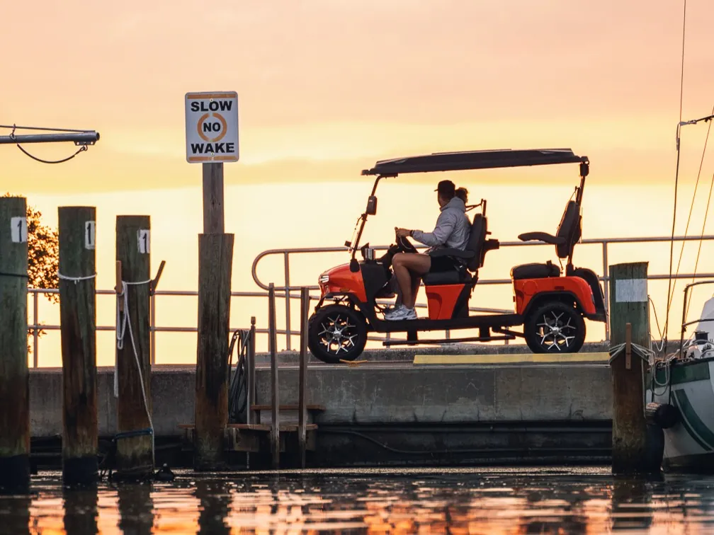 Golf cart on a marina dock at sunset
